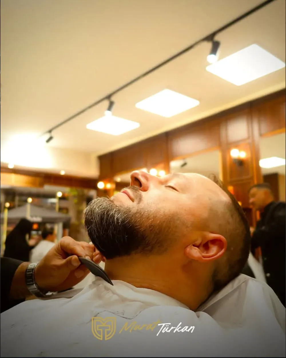 Bartpflege bei Murat Türkan Barber in Leverkusen: Halskontur wird im zurückgelehnten Barberstuhl ausgearbeitet