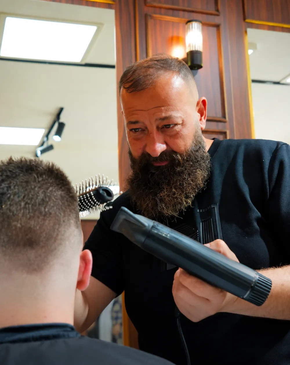 Styling nach dem Herrenhaarschnitt bei Murat Türkan Barber in Leverkusen: Barber föhnt das Deckhaar in Form