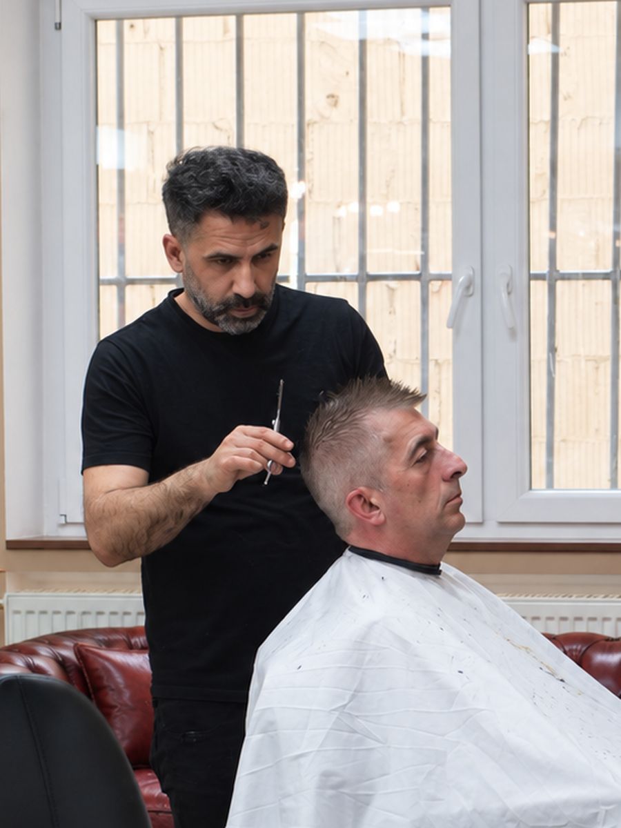 Erhan, Barber im Murat Türkan Barber Salon, bei der Arbeit