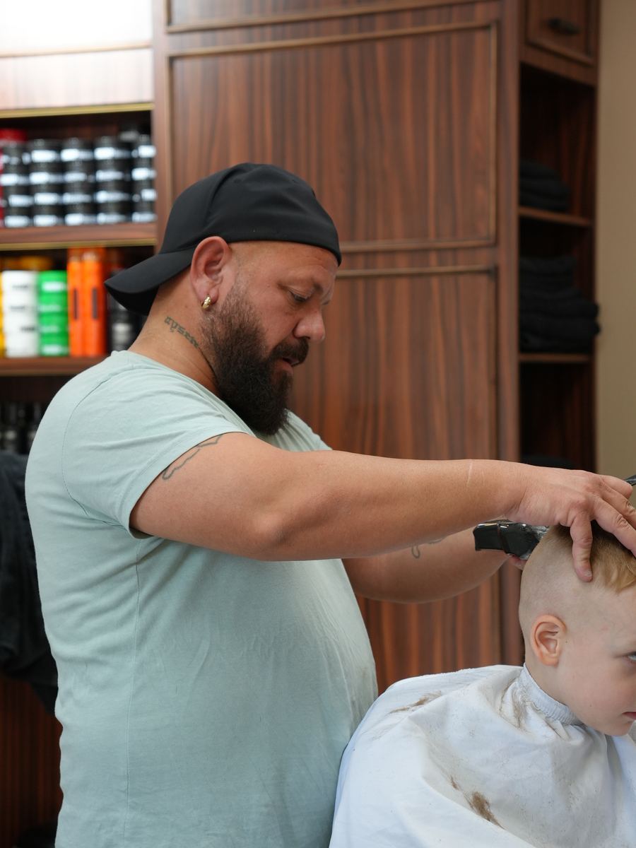 Ersin, Barber im Murat Türkan Barber Salon, bei der Arbeit