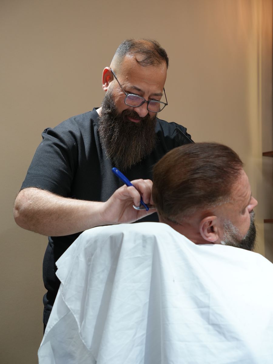 Murat Türkan, Inhaber und Master Barber, bei der Arbeit am Kunden